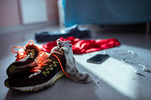 Sport Clothing Close up of shoes and clothing of an athlete after a workout running shoes on floor stock pictures, royalty-free photos & images