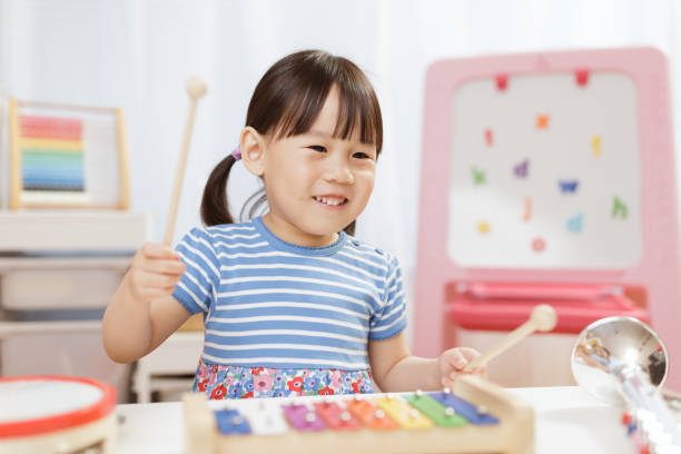 bambina giocare xylophone a casa per homeschooling - toddler music asian ethnicity child foto e immagini stock