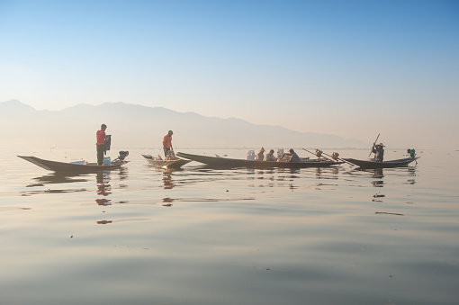 Inle, Shan State, Myanmar -  Febuary 25 2014 ; Intha fisherman in Inle Lake at sunrise, Traditional leg rowing of the Intha fisherman Inle, Shan State, Myanmar.