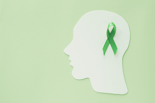 recorte de papel cerebral con cinta verde sobre fondo verde, concepto de salud mental, día mundial de la salud mental photo