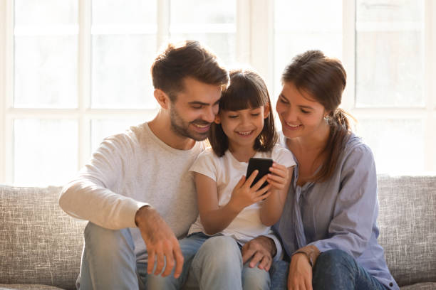 istock Little kid daughter holding cellphone enjoy using mobile app 1220704553
