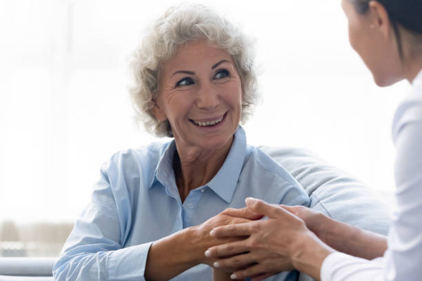istock Caring nurse holding older woman hands, expressing support and empathy 1220704616