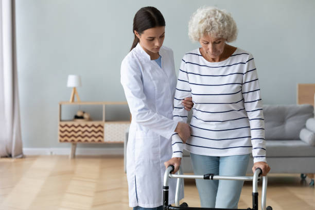 istock Serious doctor teaching disabled older woman to use walker 1220704636