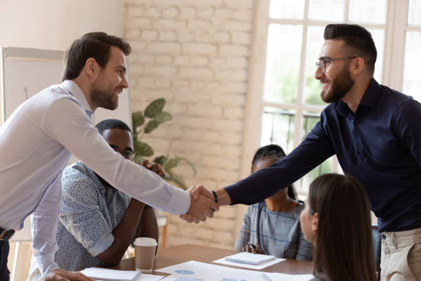 istock Diverse business partners shake hands accomplish negotiations 1220704714