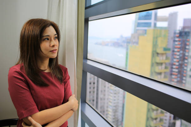 istock woman think stand near the window 1220705453