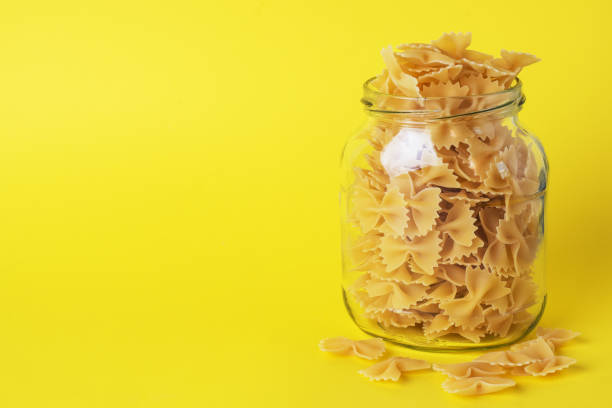 Dry pasta in a glass jar. Copy space. Concept of food storage, donations. Dry pasta in a glass jar. Copy space. Concept of food storage, donations carbohydrate food type photos stock pictures, royalty-free photos & images