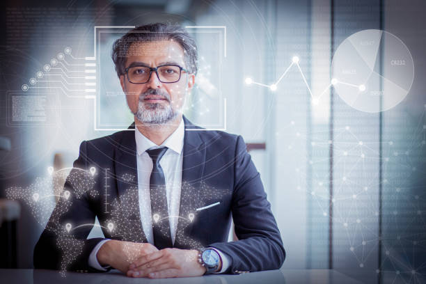 istock Serious man sitting at desk and virtual identification graphics 1220710396