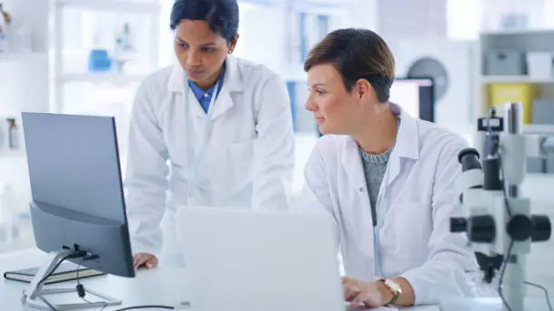 Shot of two scientists working together on a computer in a lab