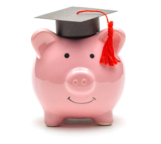 istock Piggy bank and black graduate hat 1220711635