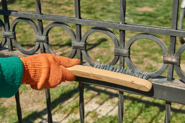 istock the master cleans the metal fence from rust 1220712290
