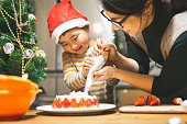 一緒にクリスマスケーキを作る母と息子