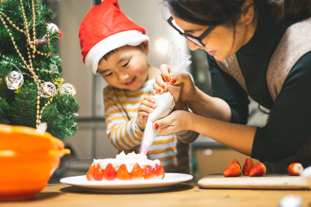 mãe e filho fazendo bolo de natal juntos - bolo de natal - fotografias e filmes do acervo