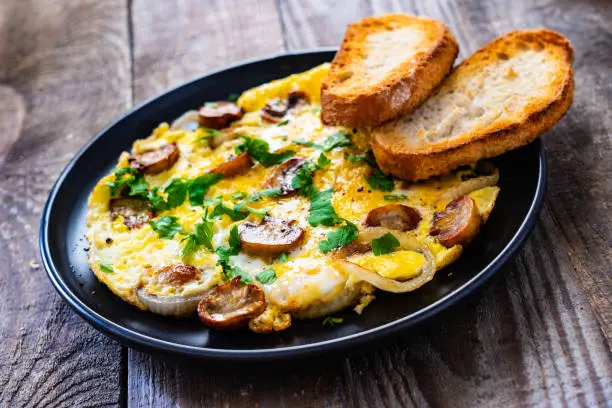 Omelet with champignons on wooden board