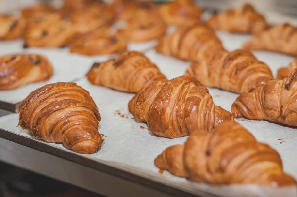 istock Freshly baked croissants on a baking sheet. Commercial kitchen. 1220716723