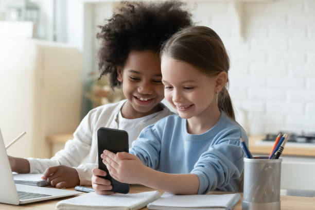 istock Happy multiracial girls study online using cellphone 1220716899