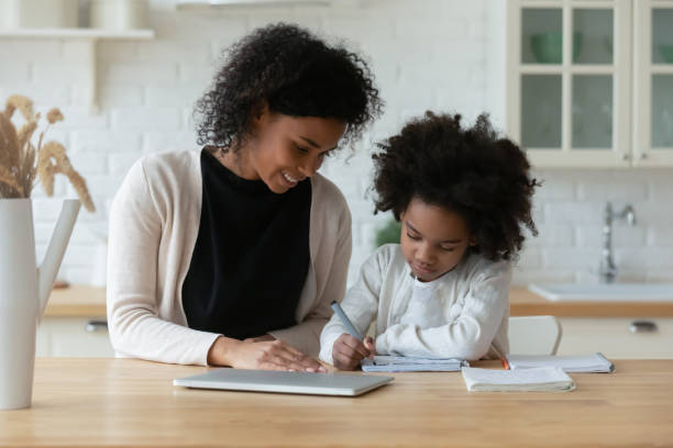 la mamma afroamericana e la figlia piccola studiano online - home schooling foto e immagini stock