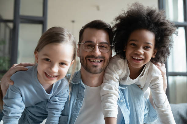 istock Overjoyed dad playing with multiracial little daughters 1220716930