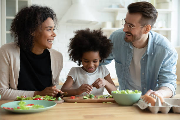 istock Young multiracial family with kid cooking in kitchen together 1220716966