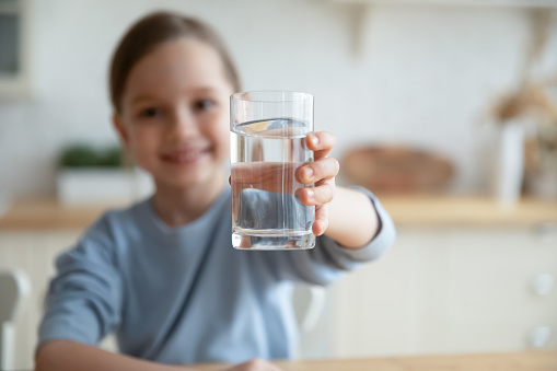 Niña ofrecen agua mineral limpia para el refresco corporal photo