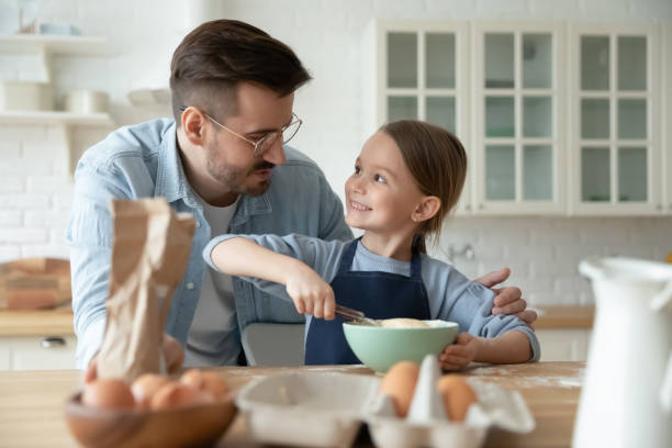 istock Loving dad and little daughter bake in kitchen at home 1220717002