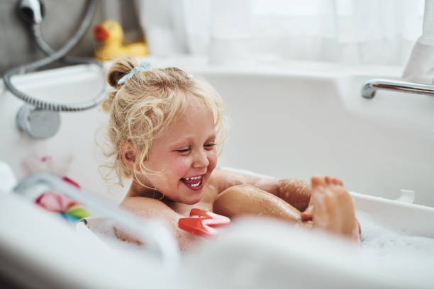 Bath time is my favourite time Cropped shot of an adorable little girl taking a bubble bath during her morning routine at home girls bath stock pictures, royalty-free photos & images
