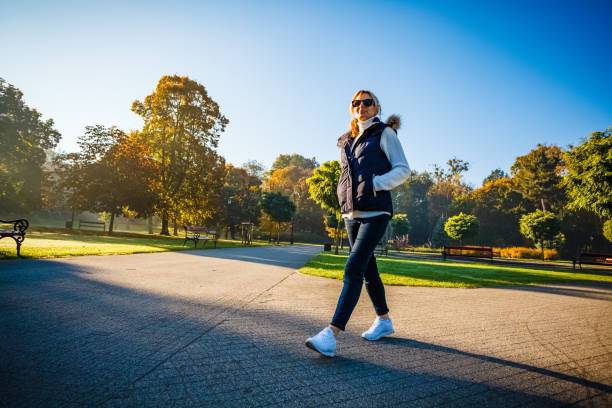 Middle-aged woman walking in city park