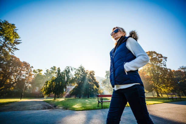istock Middle-aged woman walking in city park 1220718321