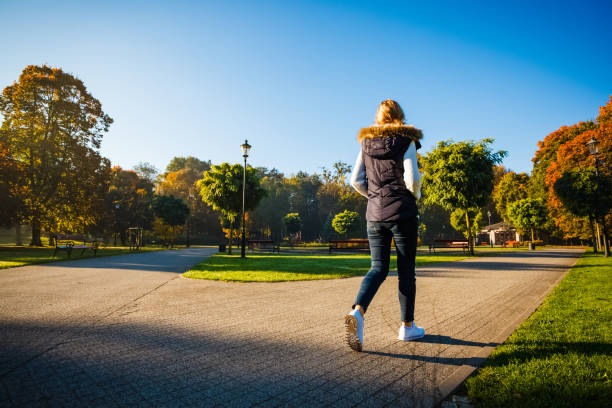 istock Middle-aged woman walking in city park 1220718357