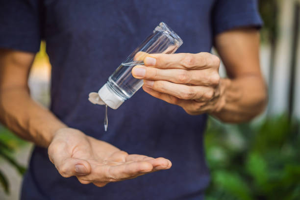 istock Men's hands using wash hand sanitizer gel 1220718538