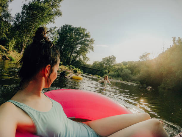 Relaxing on inflatable rings in the river Photo of girlfriends relaxing on inflatable rings in the river river swimming women water stock pictures, royalty-free photos & images