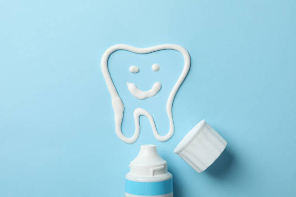istock Tooth made of toothpaste and tube on blue background, top view 1220723123