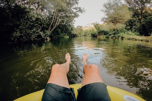 Photo of a young man relaxing on inflatable ring in the river