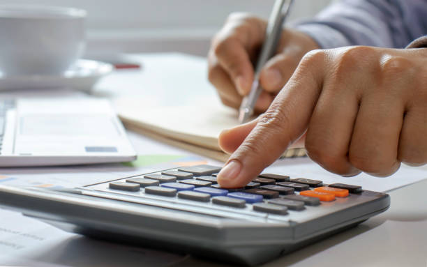 istock Close-up of women using calculators and note-taking, accounting reports, cost-calculation ideas and saving money. 1220724173