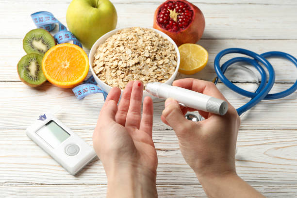 istock Female checking blood sugar level on background with diabetic accessories 1220724782