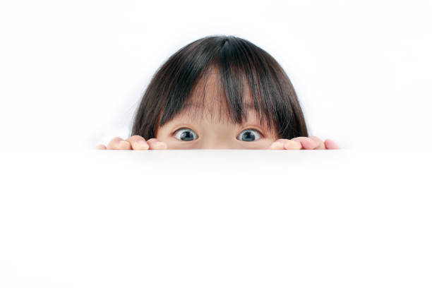 little girl peeking over table - peeking imagens e fotografias de stock