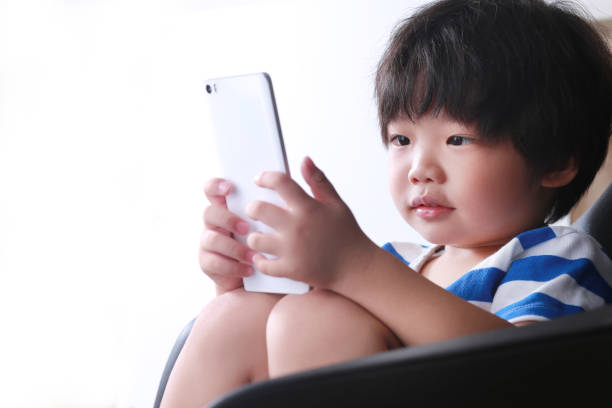 istock Little Boy playing alone on smart phone 1220725545