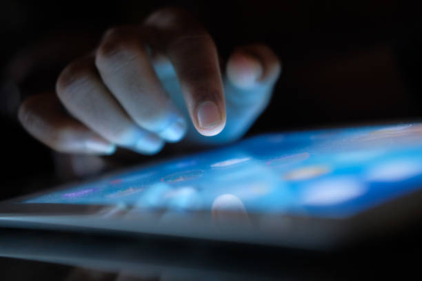 istock Close up of man hand using digital tablet at night 1220727379