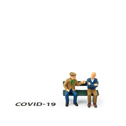 Two old men and coronavirus outbreak. Small figurines and text about Covid-19 on white background. Coronavirus prevention, social distancing and Quarantine concept.
