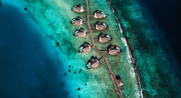 Maldives Island Lagoon with Water Villas Maldives Island Resort Lagoon with Water Villas from above. Luxurious Over Water Villas are typical for the Maldives. jetty aerial stock pictures, royalty-free photos & images