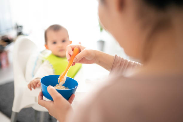 istock Parent feeding their little baby 1220729415
