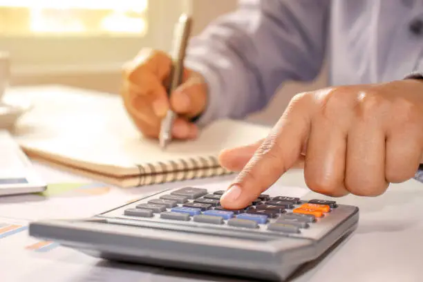 Photo of Close-up of women using calculators and note-taking, accounting reports, cost-calculation ideas and saving money.