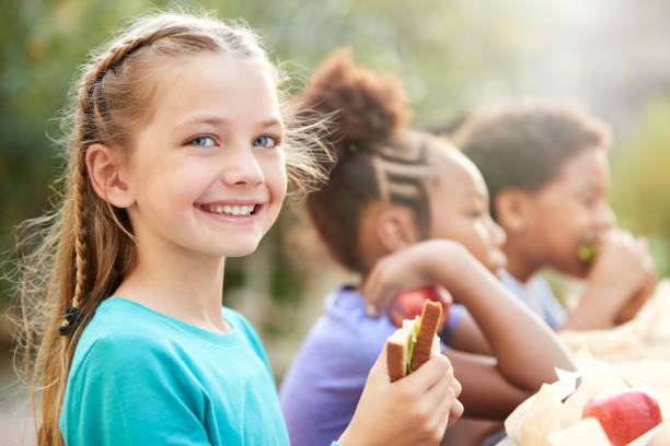 portret dziewczyny z przyjaciółmi jedzenie zdrowego pikniku na zewnątrz tabeli na wsi - apple eating healthy eating friendship zdjęcia i obrazy z banku zdjęć