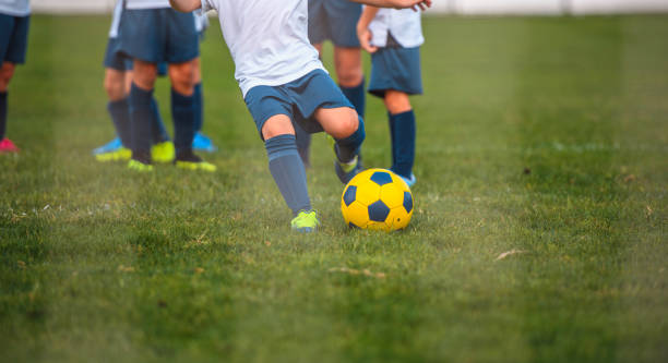 若い男の子サッカー選手練習ゴールキックの部分的なビュー - 2966 ストックフォトと画像