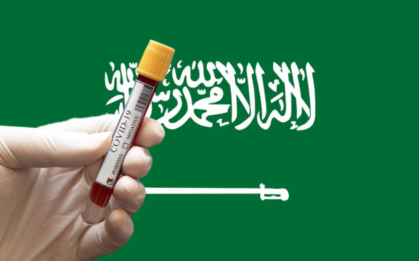 Close-up of a Positive COVID-19 blood test sample tube with Flag of Saudi Arabia at background. stock photo