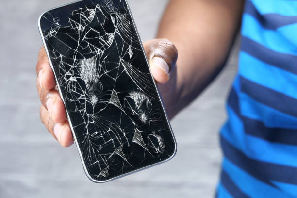 istock Close up of man hand holding broken smart phone 1220732874