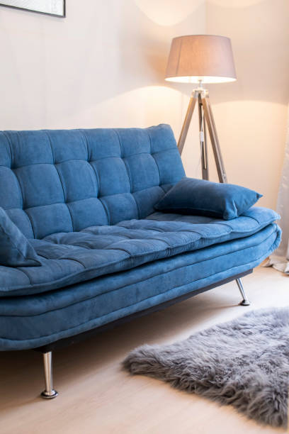 istock Comfy blue sofa and a standing lamp in a minimalist living space. 1220732949