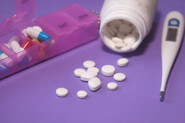 istock colorful pills spilling from container on color background 1220733639