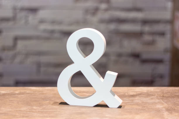 istock ampersand & sign on wood table with blurred wall background 1220734606