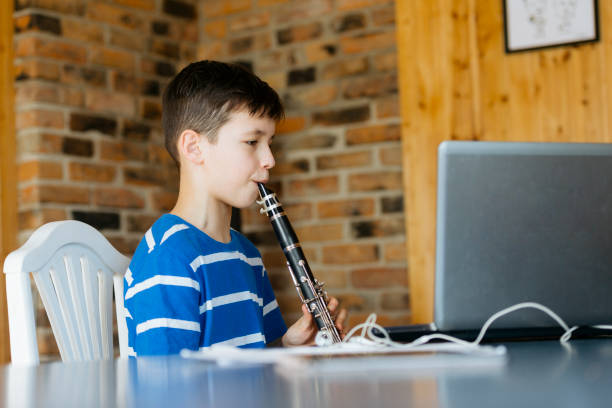 junge mit klarinette spielt musik. konzept des online-musikunterrichts - practicing piano child playing stock-fotos und bilder