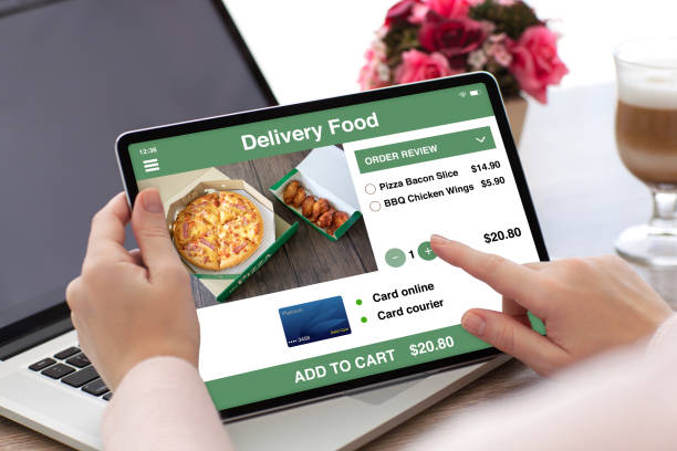 istock woman hands holding tablet computer with app delivery food 1220737328